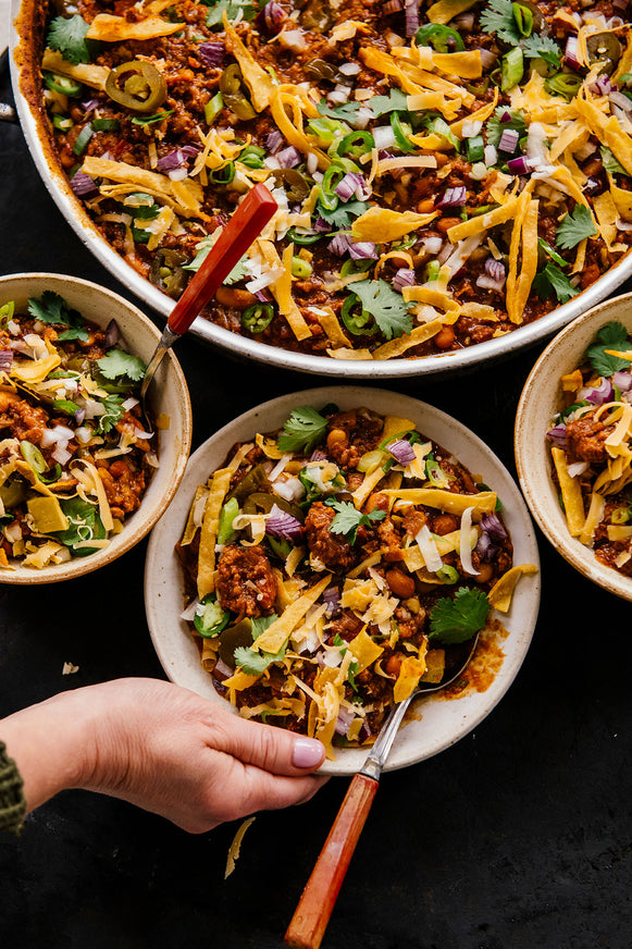 Bowls of the People's Chili topped with cheese, tortilla chips 