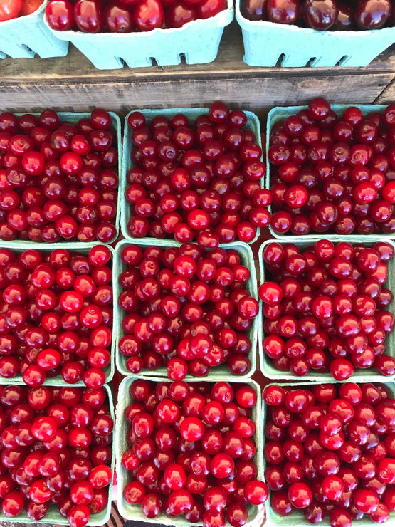 Load image into Gallery viewer, Turquoise quart boxes filled with bright red sour cherries.
