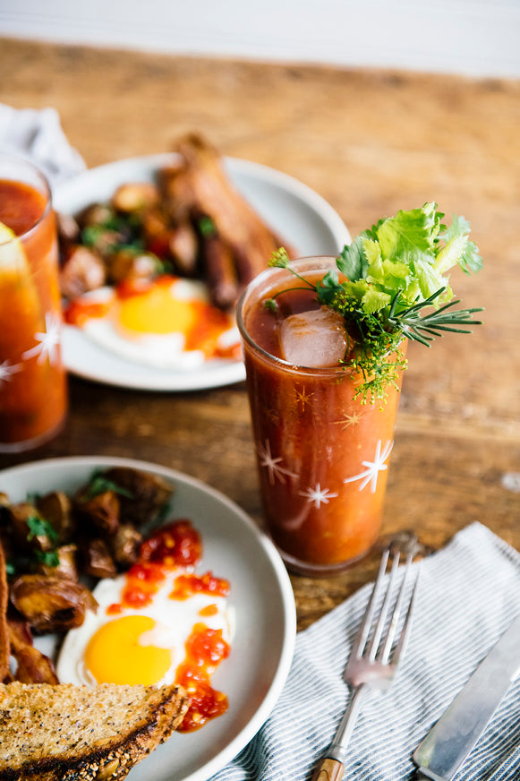 Brunch including eggs topped with Chili Jam and Bloody Mary's topped with celery and herbs