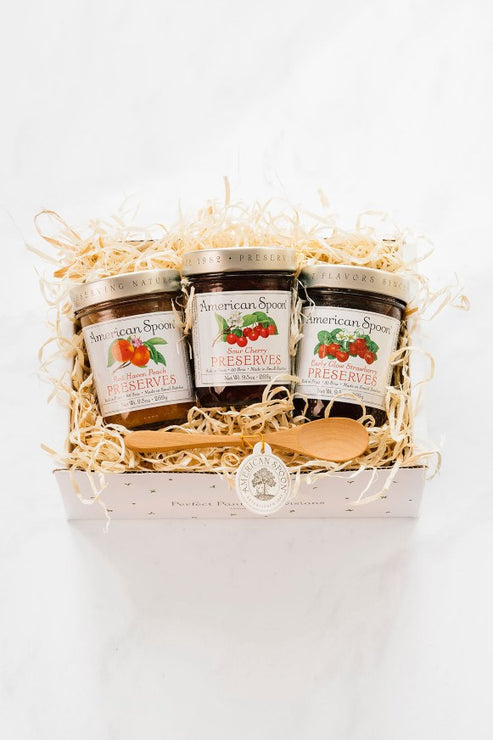 Load image into Gallery viewer, The Favorite Preserve Trio gift box containing Red Haven Peach Preserves, Sour Cherry Preserves, Early Glow Strawberry Preserves and a wooden jam spoon
