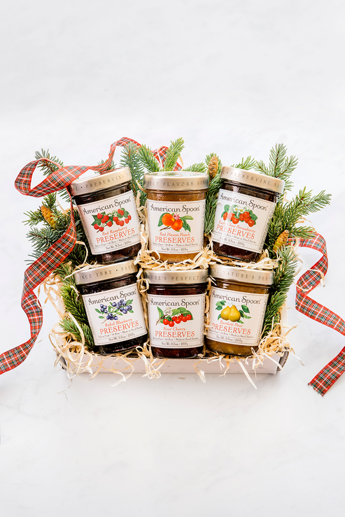 Load image into Gallery viewer, A holiday version of the Michigan Six Pack including Early Glow Strawberry Preserves, Red Haven Peach Preserves, Sour Cherry Preserves, Heirloom Blueberry Preserve, Red Raspberry Preserves and Bartlett Pear Preserves surrounded by greenery and holiday ribbon 
