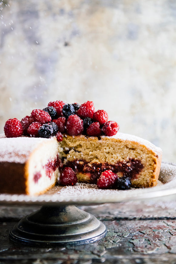 Cake filled with jam and topped with fresh berries