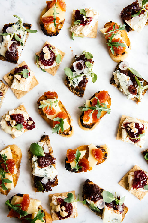 Load image into Gallery viewer, Crackers topped with blue cheese, arugula, preserves and conserves
