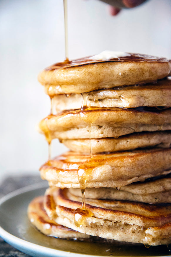A stack of pancakes with Maple Syrup drizzled on top
