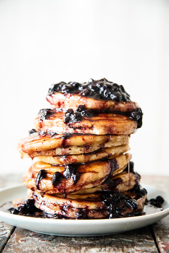 A stack of pancakes topped with Fruit Perfect Sour Cherries and Blueberries