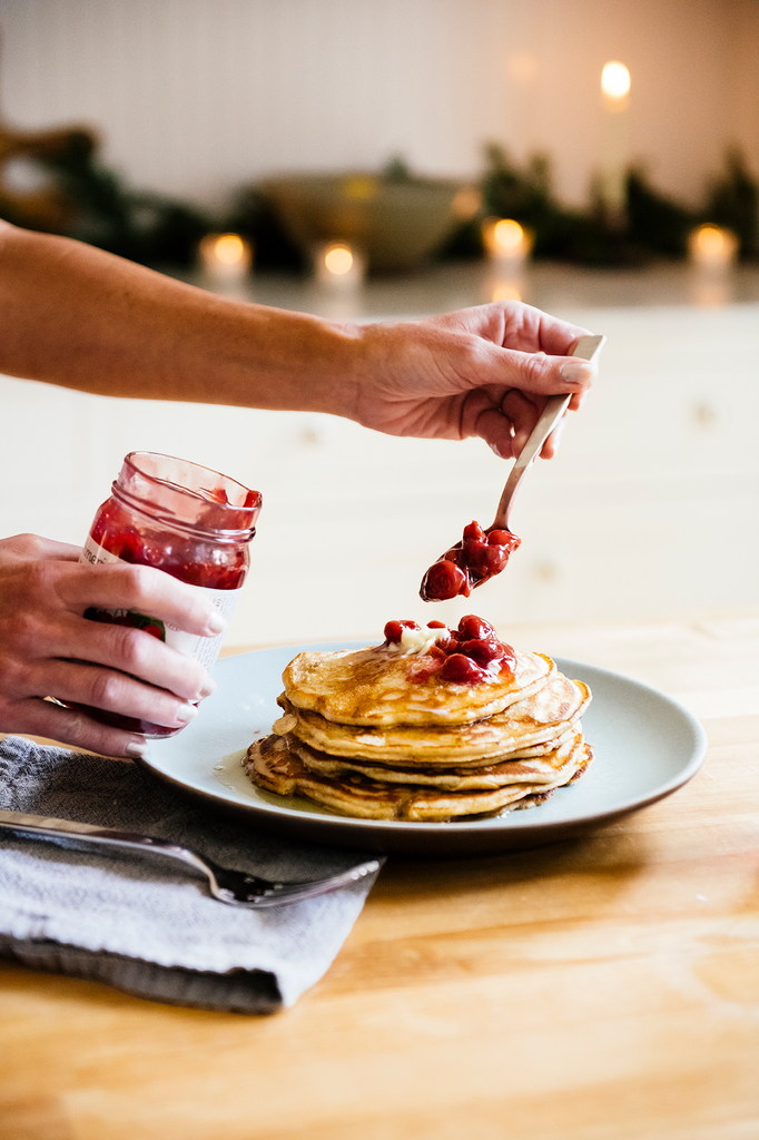 A stack of pancakes with Fruit Perfect Sour Cherries being spooned on top