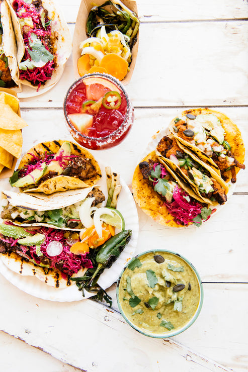 Load image into Gallery viewer, Plates of tacos topped with American Spoon salsa, a cocktail made with Paloma Mix and fresh guacamole
