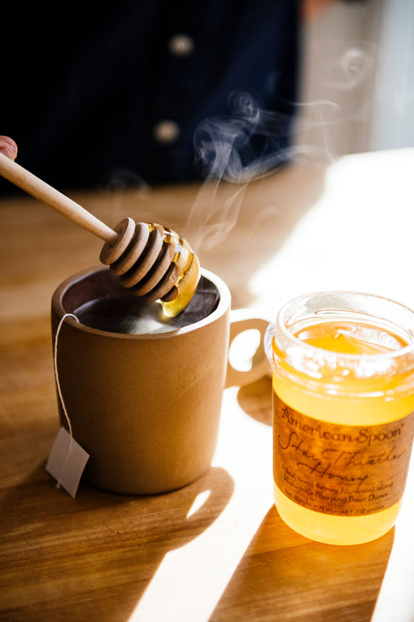 Star Thistle Honey being drizzled into a mug of tea