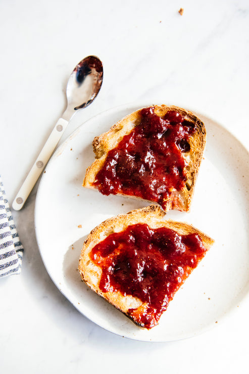 Load image into Gallery viewer, A piece of toast cut in half with Fruit Perfect spread on top
