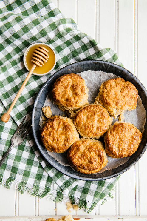 Load image into Gallery viewer, Homemade biscuits with honey dipper and honey set to the side
