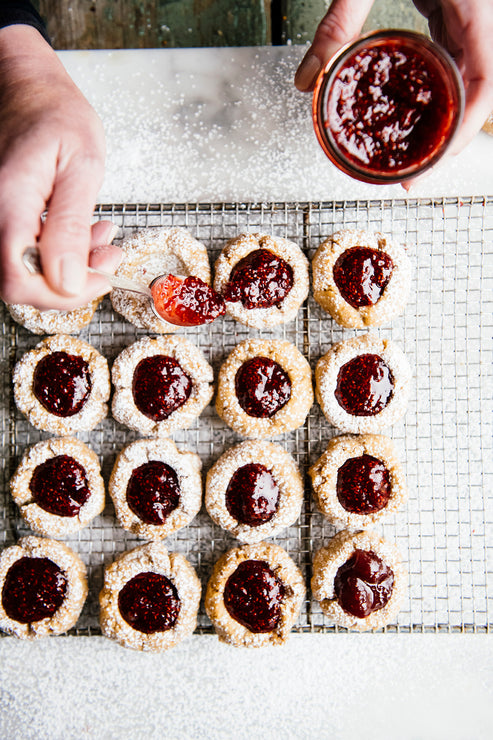 Load image into Gallery viewer, Thumbprint cookies being filled with preserves
