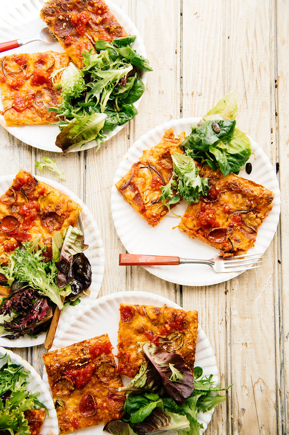 Plates of homemade pizza and salad topped with Chili Jam