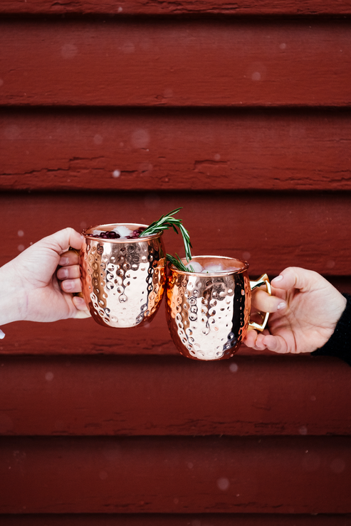 Load image into Gallery viewer, Clinking copper cups with holiday punch and sprigs of rosemary

